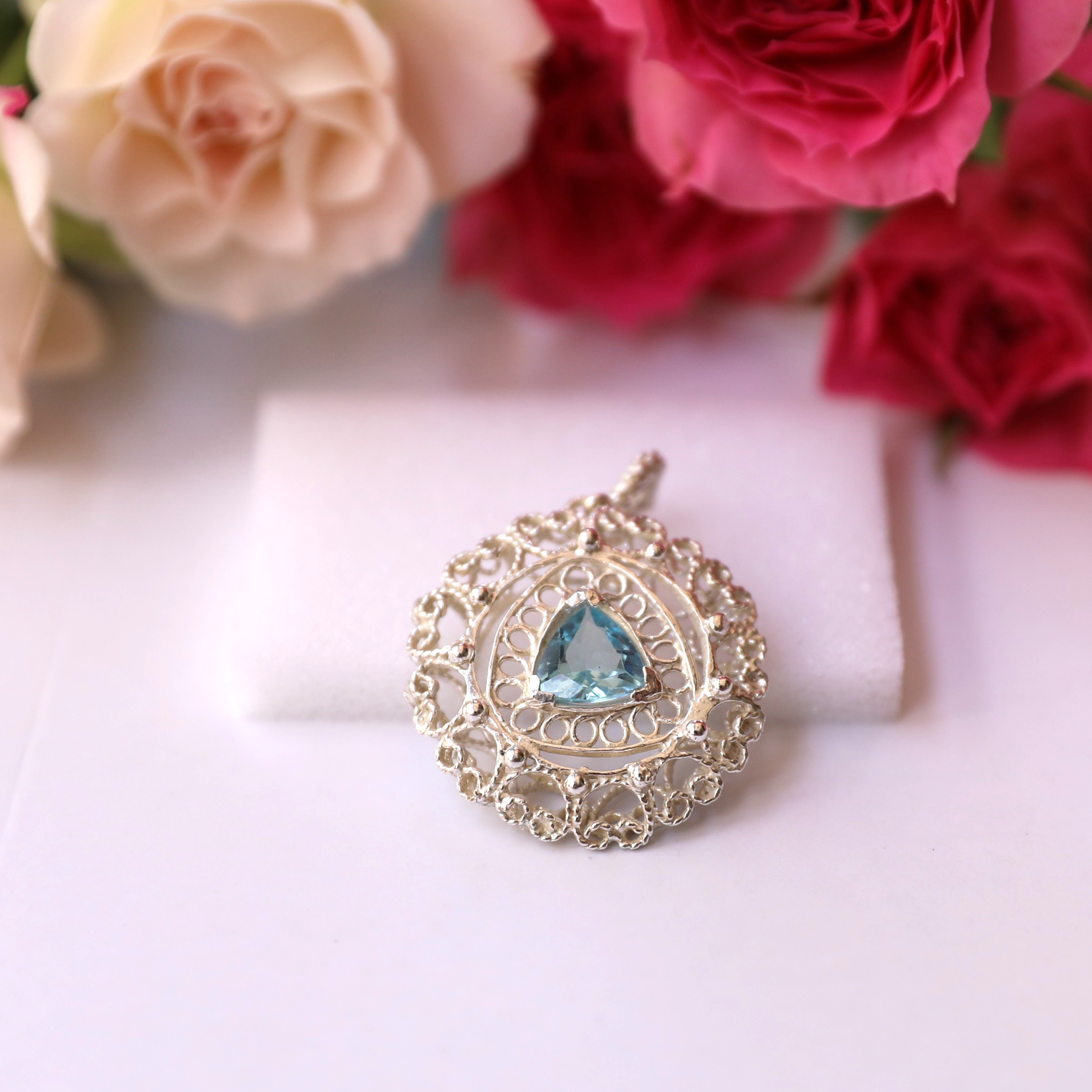 Colgante artesanal de plata con topacio azul y diseño de mandala redondo